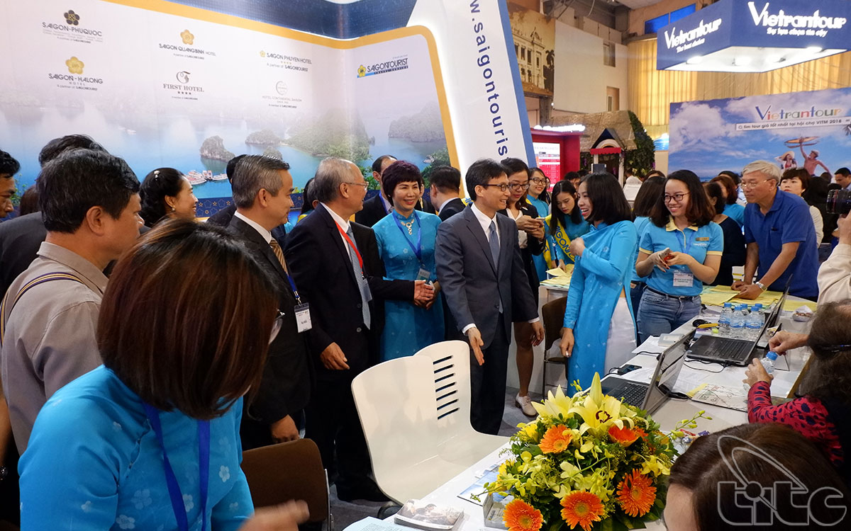 Deputy Prime Minister Vu Duc Dam visits the booths at the travel mart