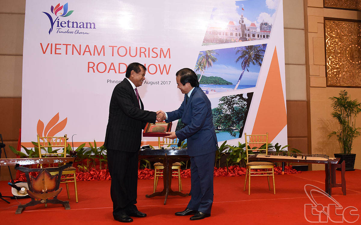 Representatives of Viet Nam and Cambodia give present each other.